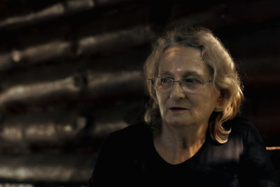 Portrait of elderly woman in glasses close-up on natural background. sunset light on face of senior