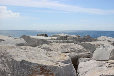 Rocks on beach against sky