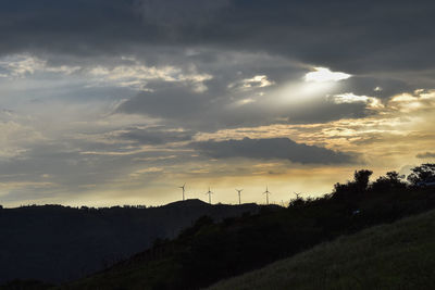 Scenic view of dramatic sky over silhouette landscape