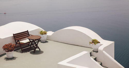 High angle view of table and bench on building terrace by sea