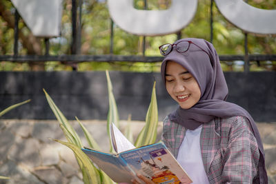 Portrait of young woman reading book