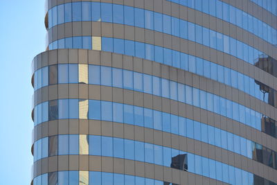 Low angle view of modern building against blue sky