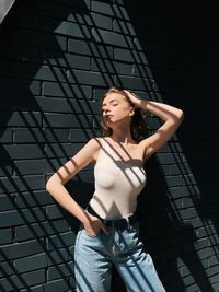 Portrait of woman standing against wall