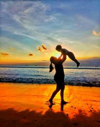 Silhouette of person standing on beach during sunset