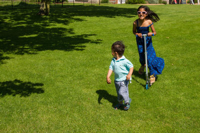 Boy running on grassy field in park