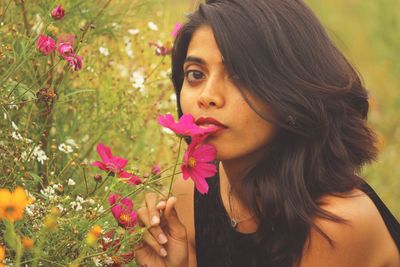 Close-up portrait of beautiful woman with pink flower