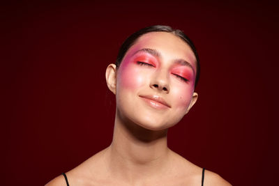 Portrait of young woman against yellow background