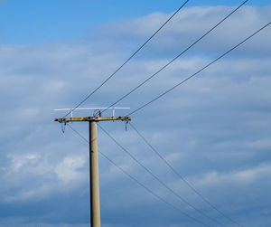 Low angle view of electricity pylon against sky