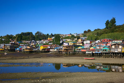 Houses and buildings against clear blue sky