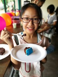 Portrait of little girl having cake at party