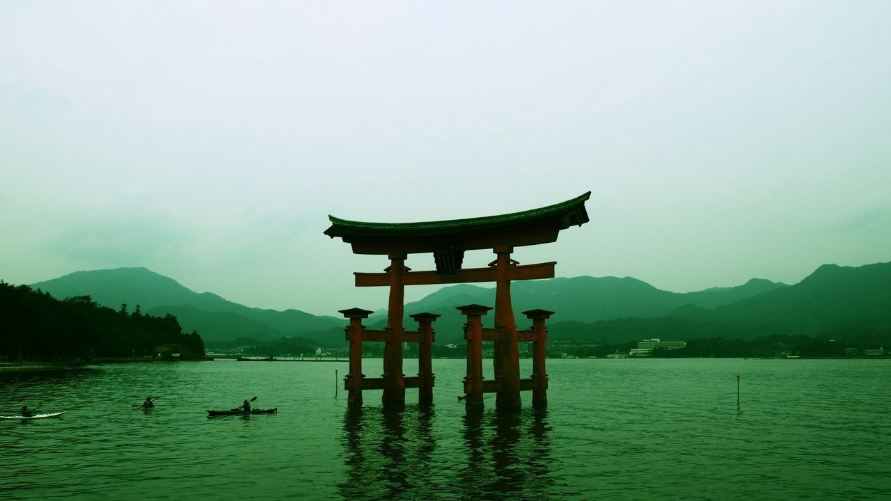 water, mountain, architecture, built structure, sky, lake, waterfront, mountain range, building exterior, tranquility, tranquil scene, river, religion, place of worship, scenics, spirituality, nature, temple - building, reflection, outdoors