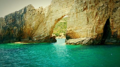 Rock formations by sea against sky