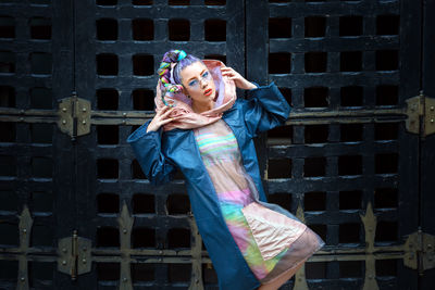 Portrait of fashionable young woman standing against wall