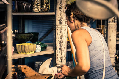 Rear view of woman standing at antique shop