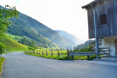 Road by mountains against clear sky