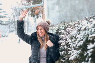 Portrait of smiling young woman standing in snow