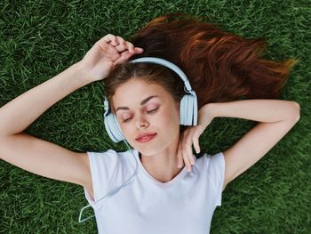 High angle view of young woman sitting on grassy field