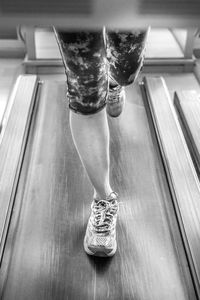 Low section of woman running on treadmill in gym