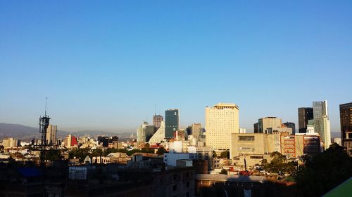 Cityscape against clear blue sky