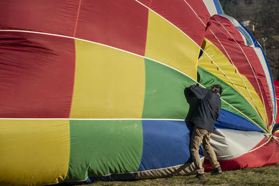 Rear view of men standing against multi colored water