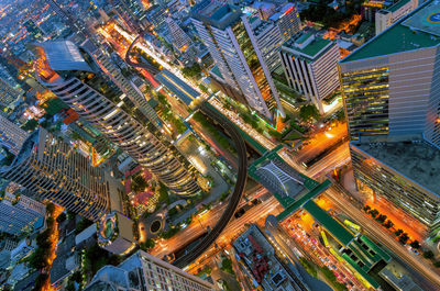 High angle view of illuminated street amidst buildings in city at night