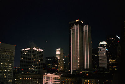 Low angle view of illuminated buildings against sky at night