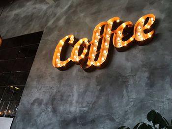 Low angle view of illuminated text on wall