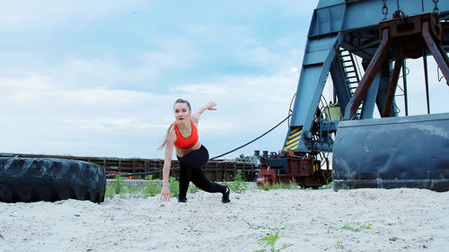 A young athletic woman in a red top and black leggings performs different strength exercises 