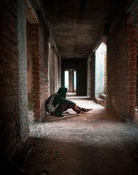Man sitting in old abandoned building
