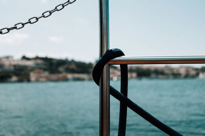 Close-up of metal railing against sea