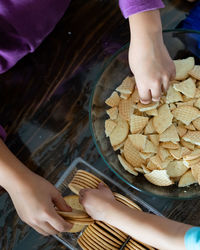 Kids making kek batik or malaysian triple chocolate dessert. crushing the cookies.