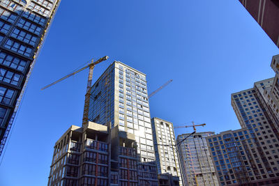 Low angle view of modern buildings against clear blue sky