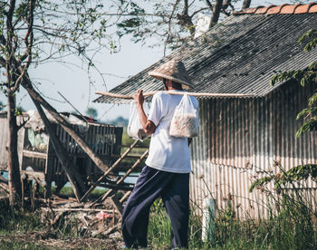 Rear view of man standing against building