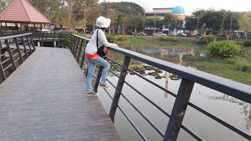 Rear view of woman standing on footbridge