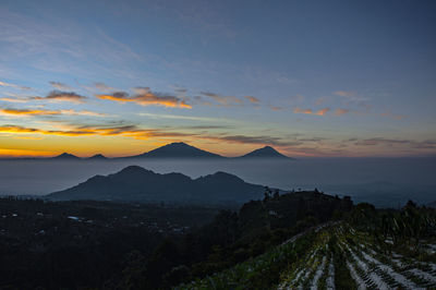 Scenic view of silhouette mountains against sky at sunset