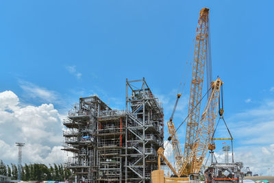 Low angle view of crane against blue sky