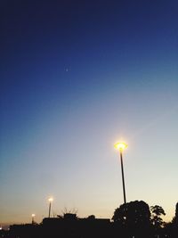 Low angle view of illuminated street light against sky