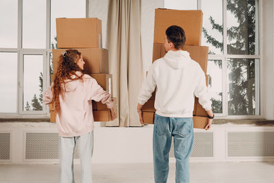 Rear view of couple standing against wall