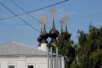 Low angle view of trees and building against sky