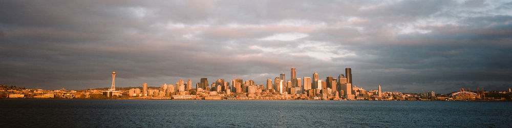 Panoramic view of buildings against cloudy sky