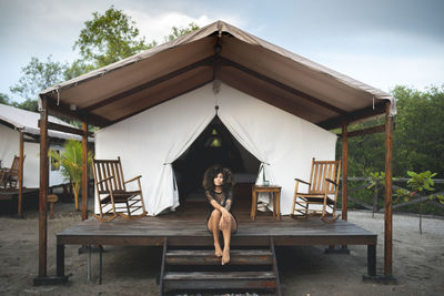 Full length portrait of woman sitting outdoors