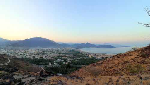 Aerial view of townscape and mountains against sky