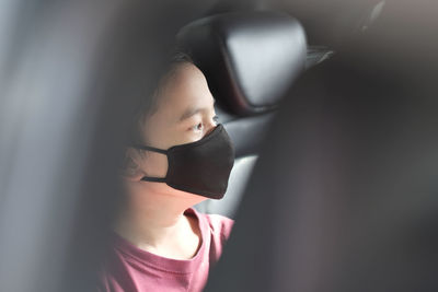 Boy with mask in car