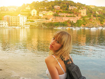 Woman standing against harbor during sunset