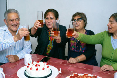 Portrait of smiling friends having food at home