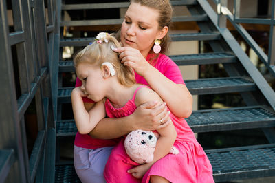 Portrait of young woman sitting on railing