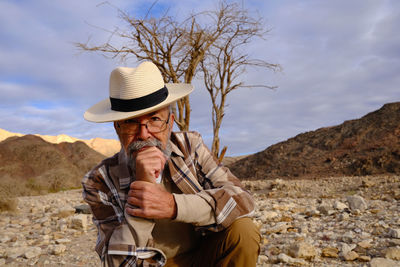 Portrait of senior man sitting in the desert 