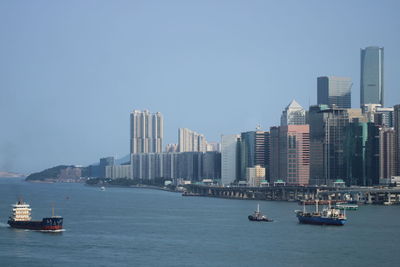 View of sea and buildings against clear sky