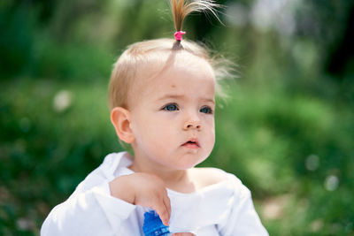 Close-up of cute girl looking away while standing outdoors