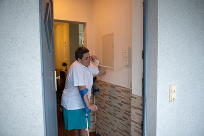 Rear view of young woman standing at home